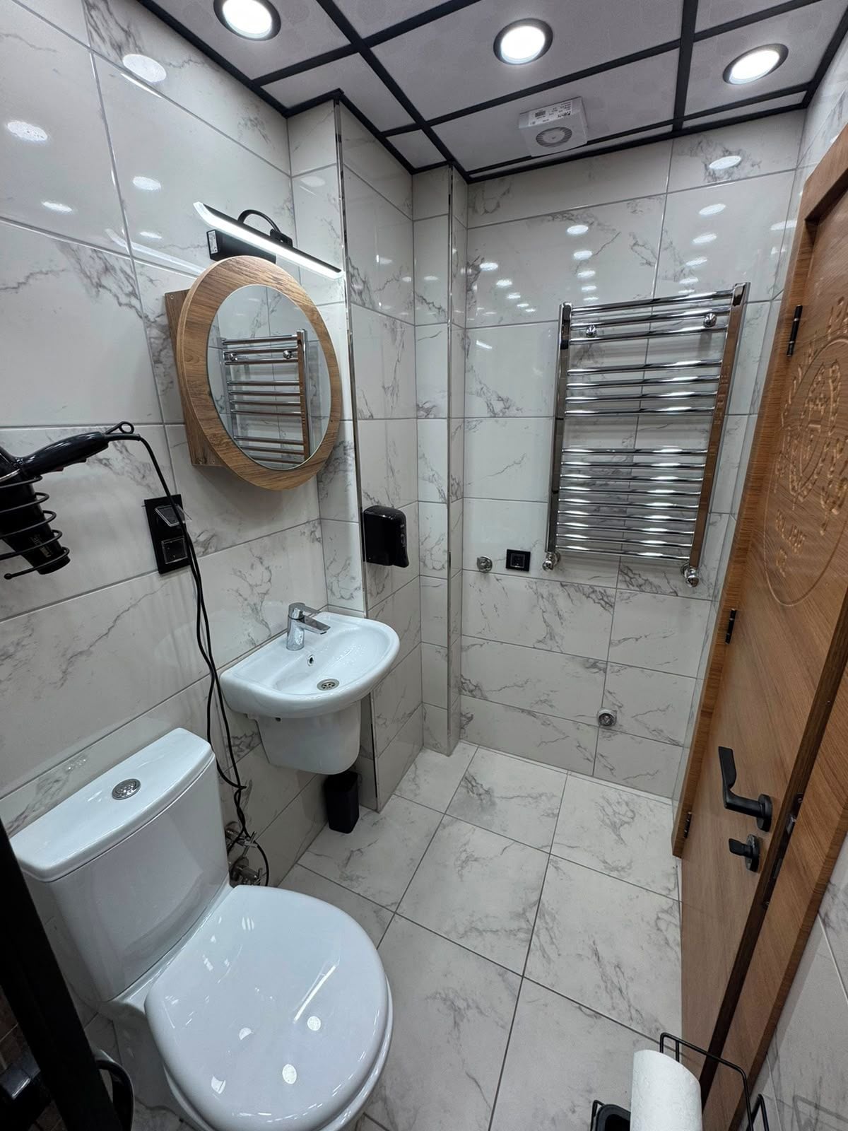 A modern bathroom with a toilet, sink, and shower.
