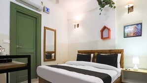 Ein Schlafzimmer mit einem Bett, einem Nachttisch, einer Lampe und einer grünen Tür.