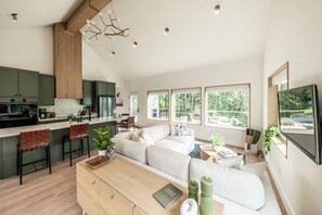 Una cocina moderna con comedor, sofá y televisor.