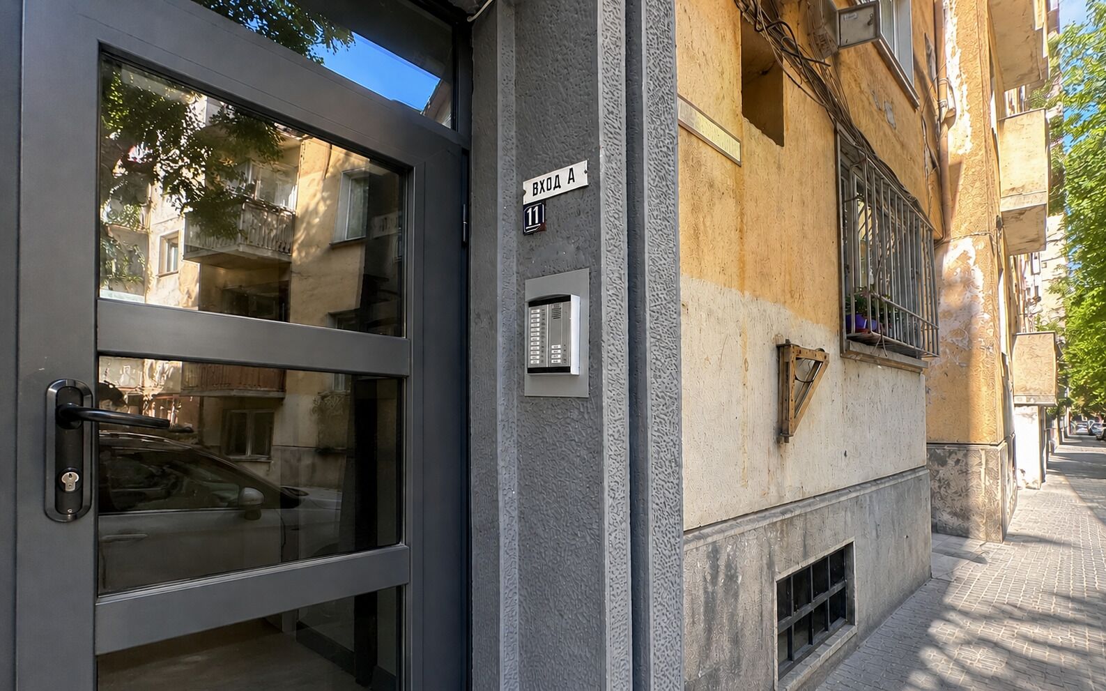 Um edifício com porta moderna, janela visível e placa com o número 11.