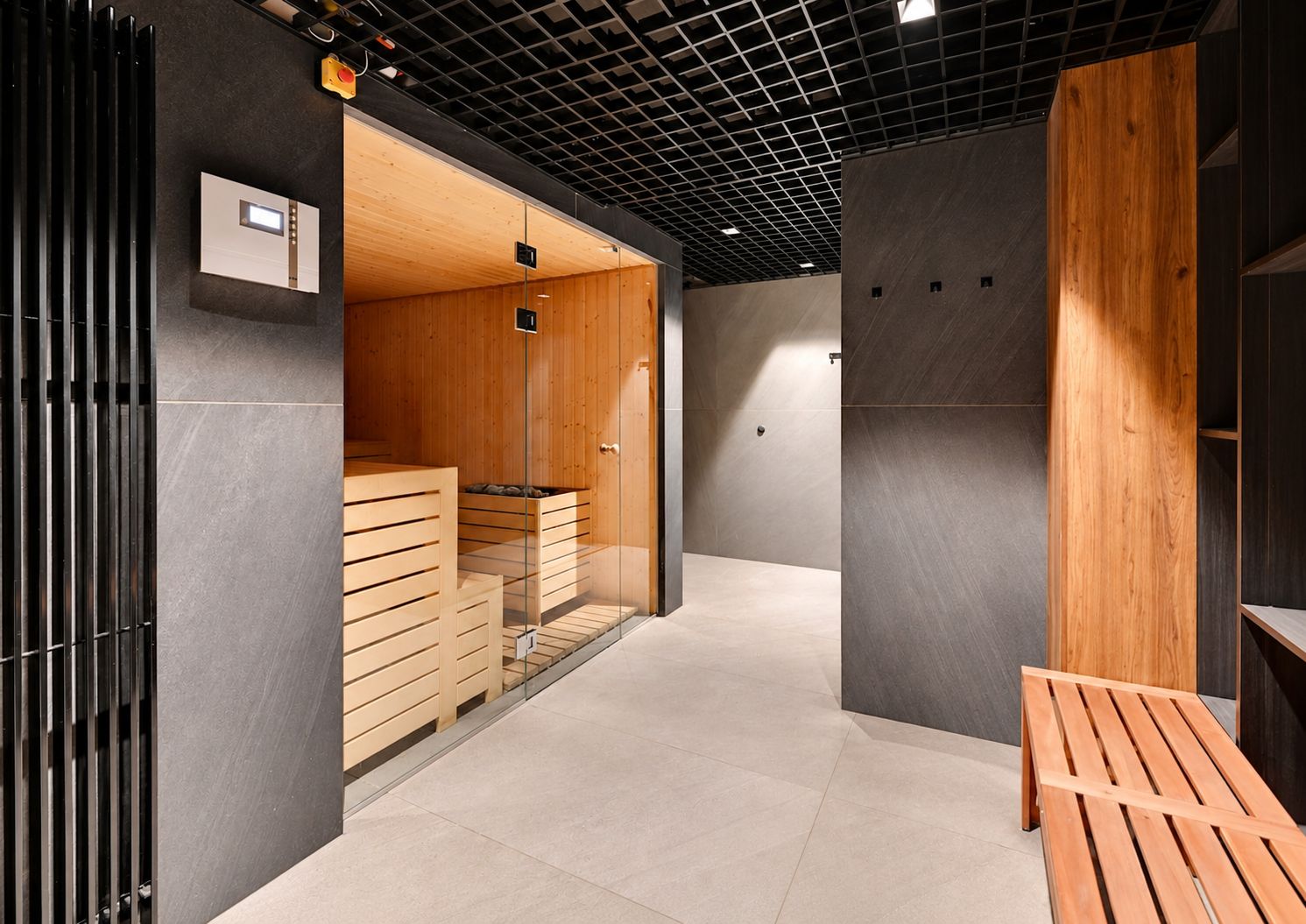 A modern interior with a sauna area, a bench, and a control panel.