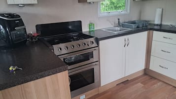 A kitchen with a gas stove, oven, and sink.