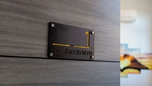 Ein Schild mit der Nummer 1 und dem Text 'SEE - Gare de Marly' an einer Wand.