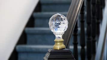 Una escala amb una bola de cristall transparent sobre la barana.
