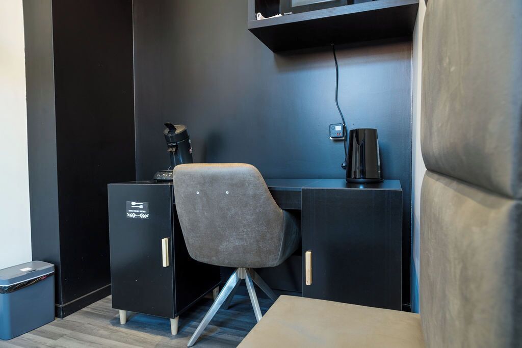 A modern office space with a desk, chair, and black filing cabinet.