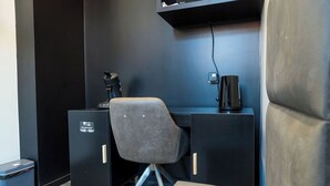 Ein moderner Arbeitsraum mit Schreibtisch, Stuhl und schwarzem Aktenschrank.