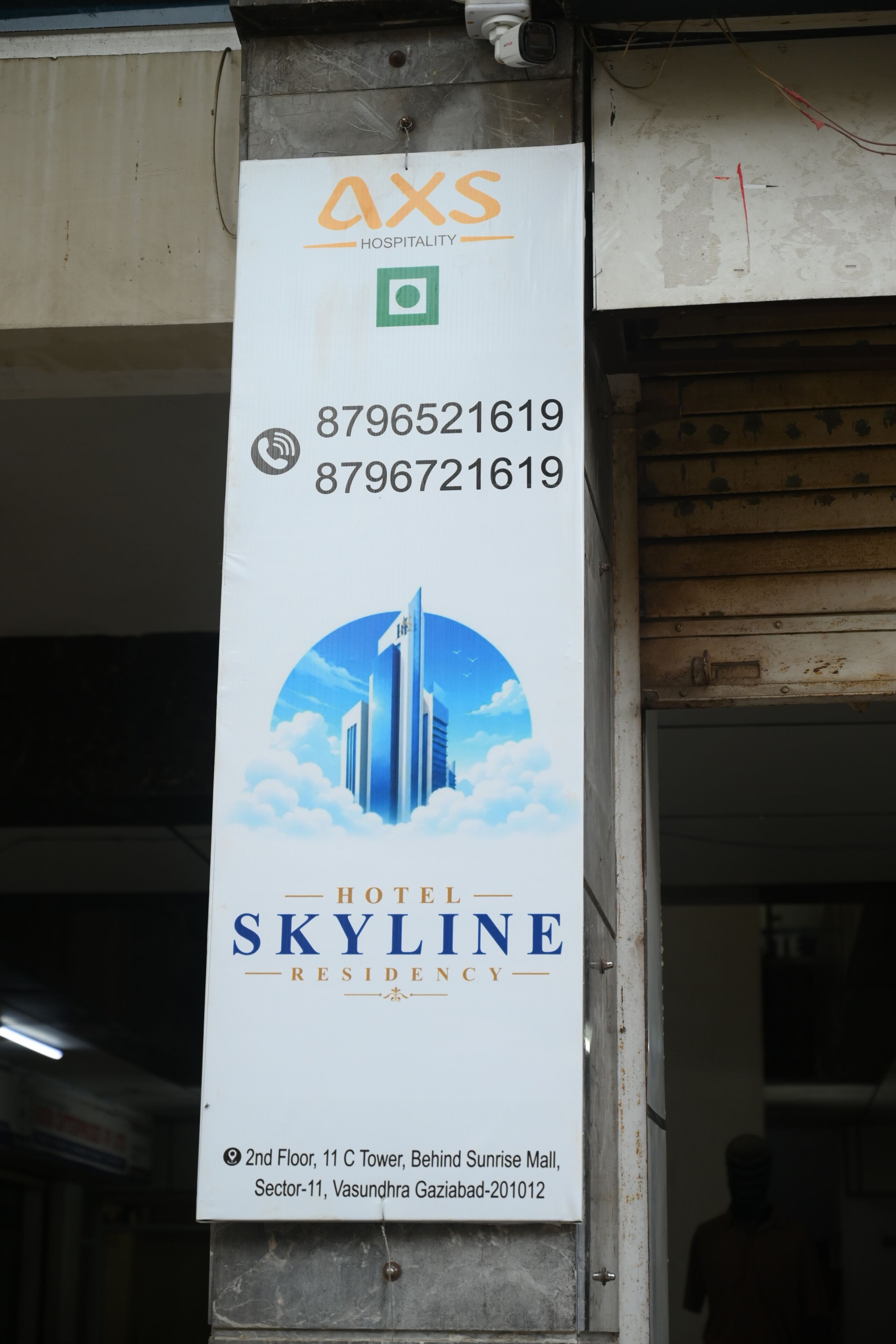 Letrero vertical del Hotel Skyline con números de contacto y detalles de ubicación.