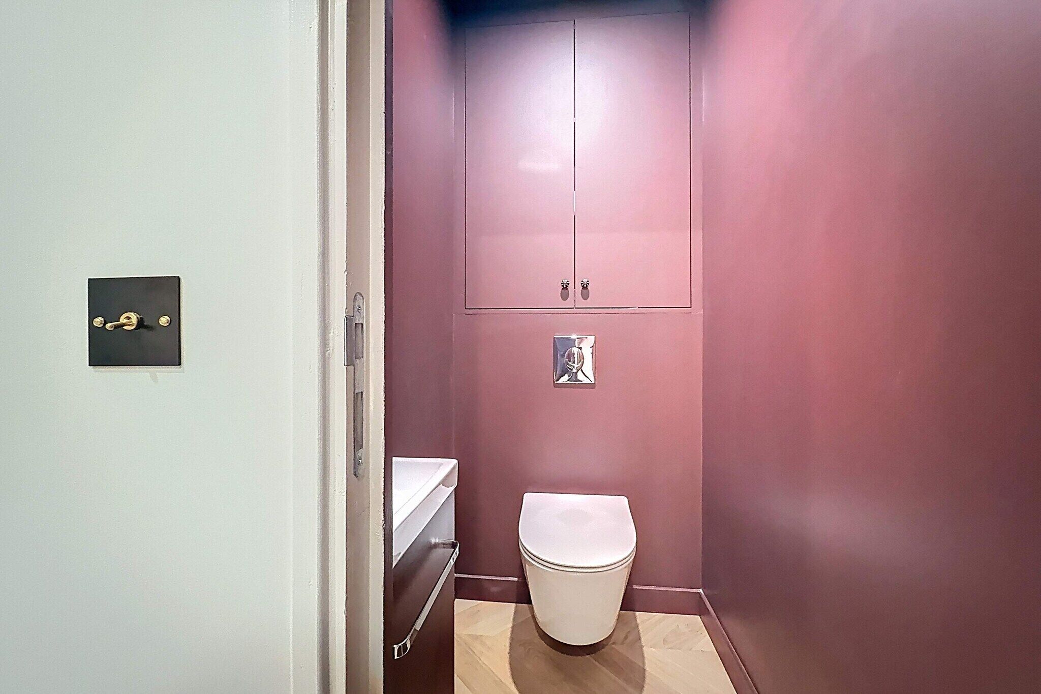 Ein kleines Badezimmer mit Toilette, Ablagefläche und Schrank.