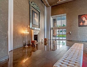 A spacious lobby with a polished floor, a fireplace, a large mirror, and a seating area. - Skyline Views 41st Fl Luxury 1BD @ ICON Brickell (Miami)
