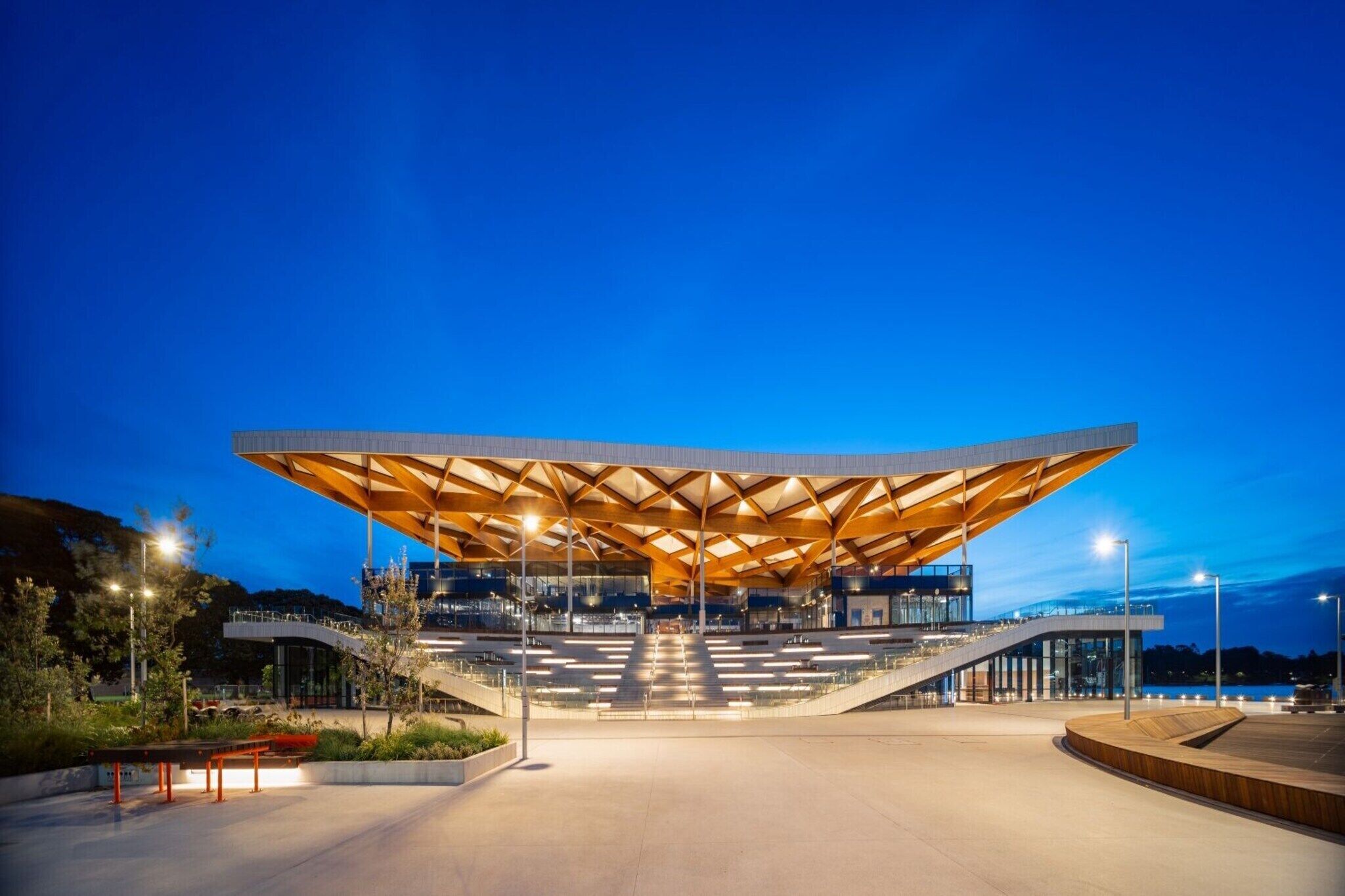 A modern architectural structure with a prominent roof and a staircase leading to an upper level.