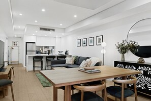 Ein moderner Wohnraum mit Essbereich, Küche und Sitzgelegenheiten.