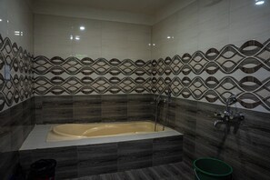 Familie suite, uitzicht op tuin | Badkamer | Een douche, handdoeken, zeep, shampoo