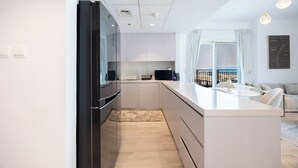 A modern kitchen with a black refrigerator, white cabinets, and a light-colored countertop. - Bloomfields 3BR plus maid in Waters Edge (Abu Dhabi)