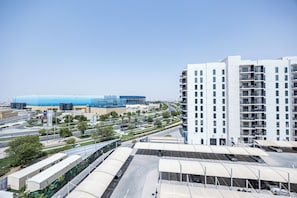 A modern building with multiple floors and balconies, surrounded by a parking area and greenery. - Bloomfields 3BR plus maid in Waters Edge (Abu Dhabi)