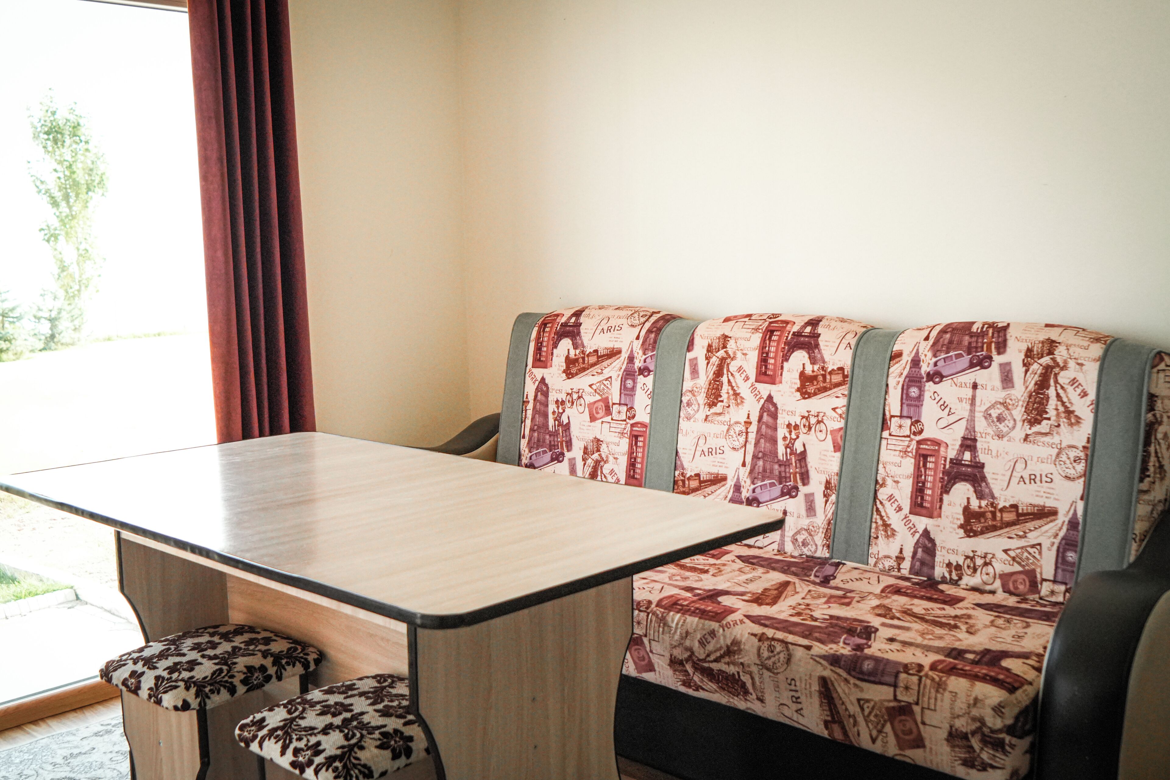 Een kamer met een bank, een tafel en twee bijpassende voetenbankjes.