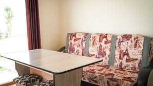 A room with a sofa, a table, and two matching ottomans.