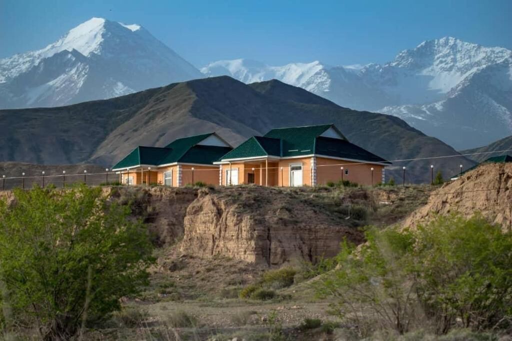 Hotel amb paisatge de muntanya, disseny modern amb terrasses verdes i estructura de teulada plana.