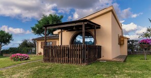 A house with a covered porch, a large arched window, and a garden with pink flowers. - 6-BED AGRITOURISM COTTAGE WITH VERANDA AND AIR-CONDITIONED GARDEN (Toscana)