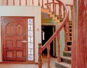 Una puerta de madera con un panel de vidrio y una escalera de caracol con barandilla de madera.