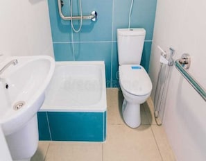 Un baño con bañera, inodoro y lavamanos.