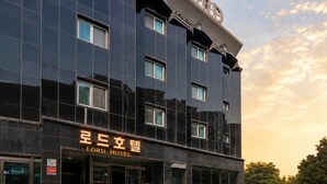 Un moderno edificio de hotel con un cartel que dice 'Lord Hotel' y una entrada visible.