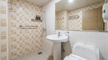 A bathroom with a shower, sink, and toilet.