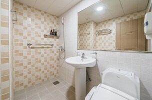 A bathroom with a shower, sink, and toilet.