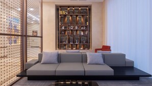 Una sala de estar moderna con un sofá modular, una chimenea de mármol y una estantería decorativa.