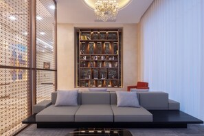 Una sala de estar moderna con un sofá modular, una chimenea de mármol y una estantería decorativa.