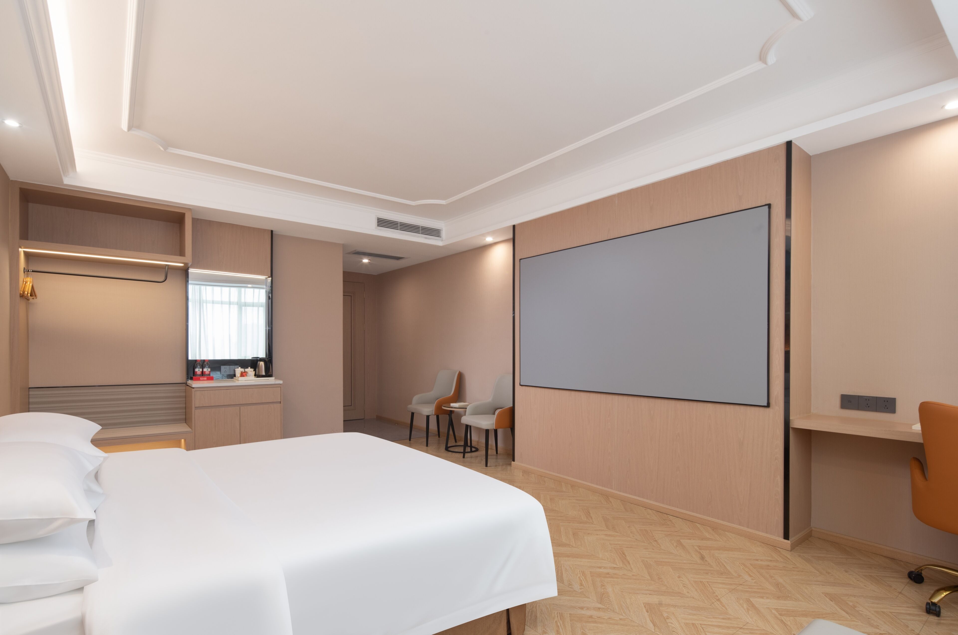 Habitación de hotel con cama, escritorio, silla, televisor de pantalla plana y ventana.