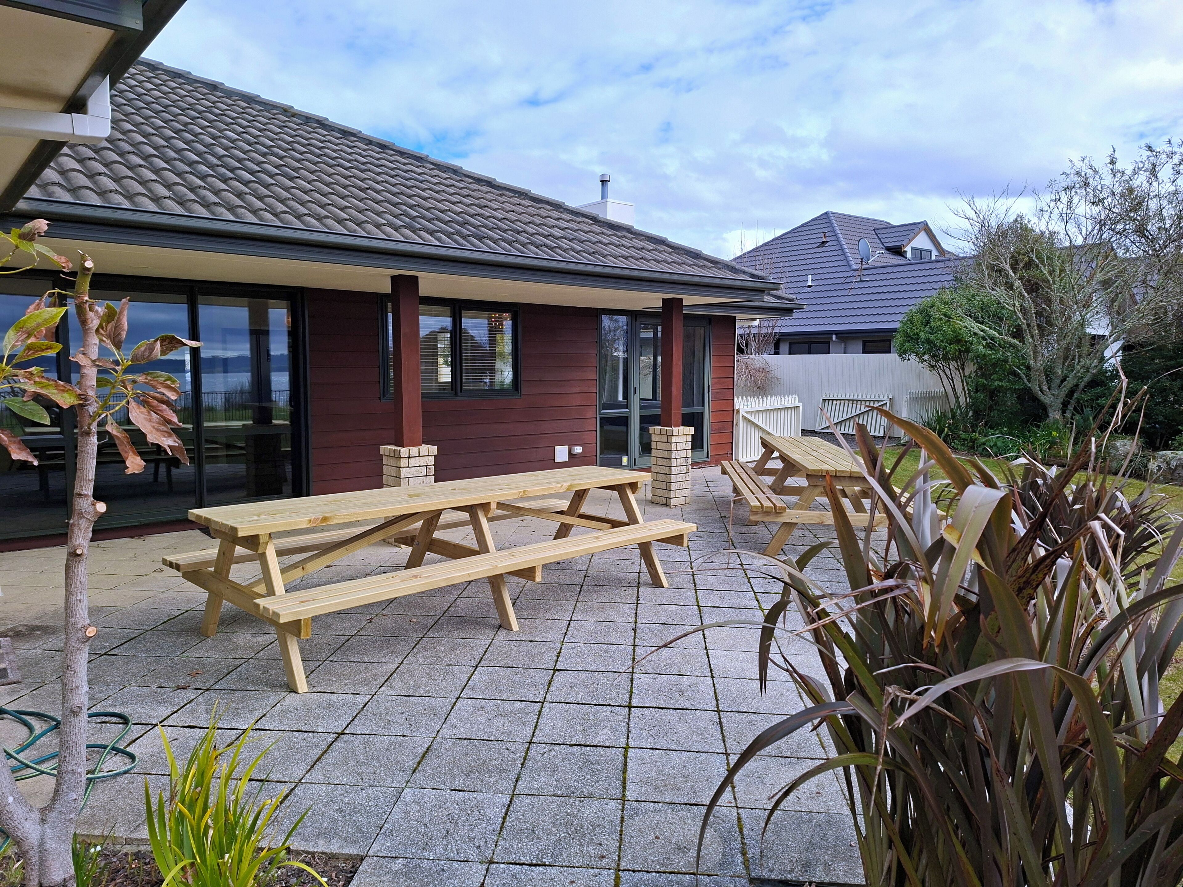 Eine Terrasse mit Picknicktischen und einem Ziegelkamin.