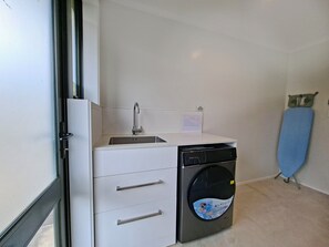 A compact kitchen with a built-in sink, a dishwasher, and a small countertop.