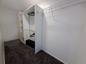 A walk-in closet with open shelving, a hanging rod, and a shoe rack.