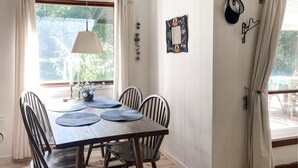 A dining area with a wooden table, four chairs, a hanging lamp, and a window with curtains. - Nice home in Frederiksværk with WiFi (Frederiksværk)