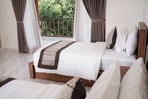 A bedroom with a bed, pillows, curtains, and a view of greenery outside.