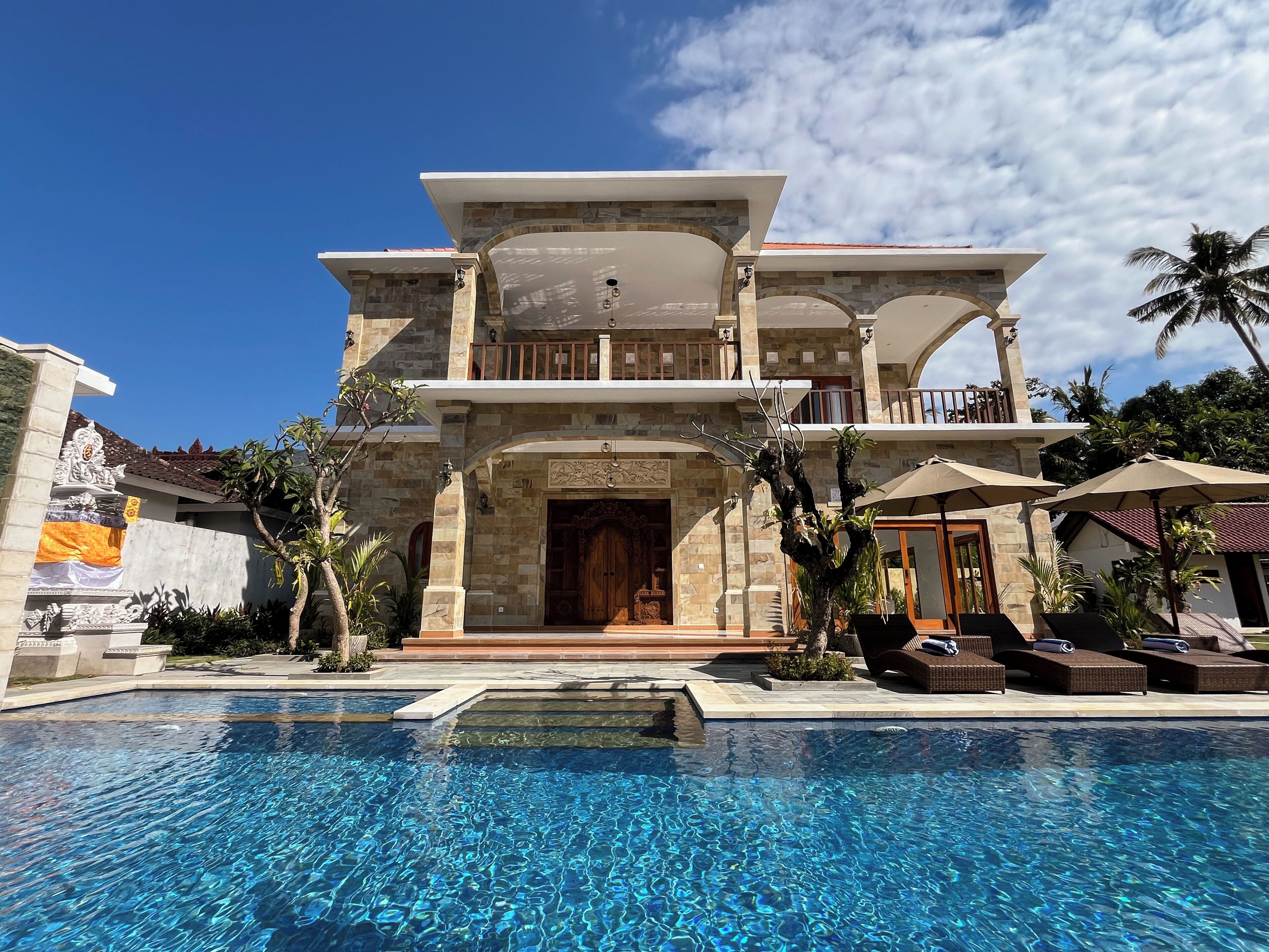 A two-story building with a swimming pool in front.