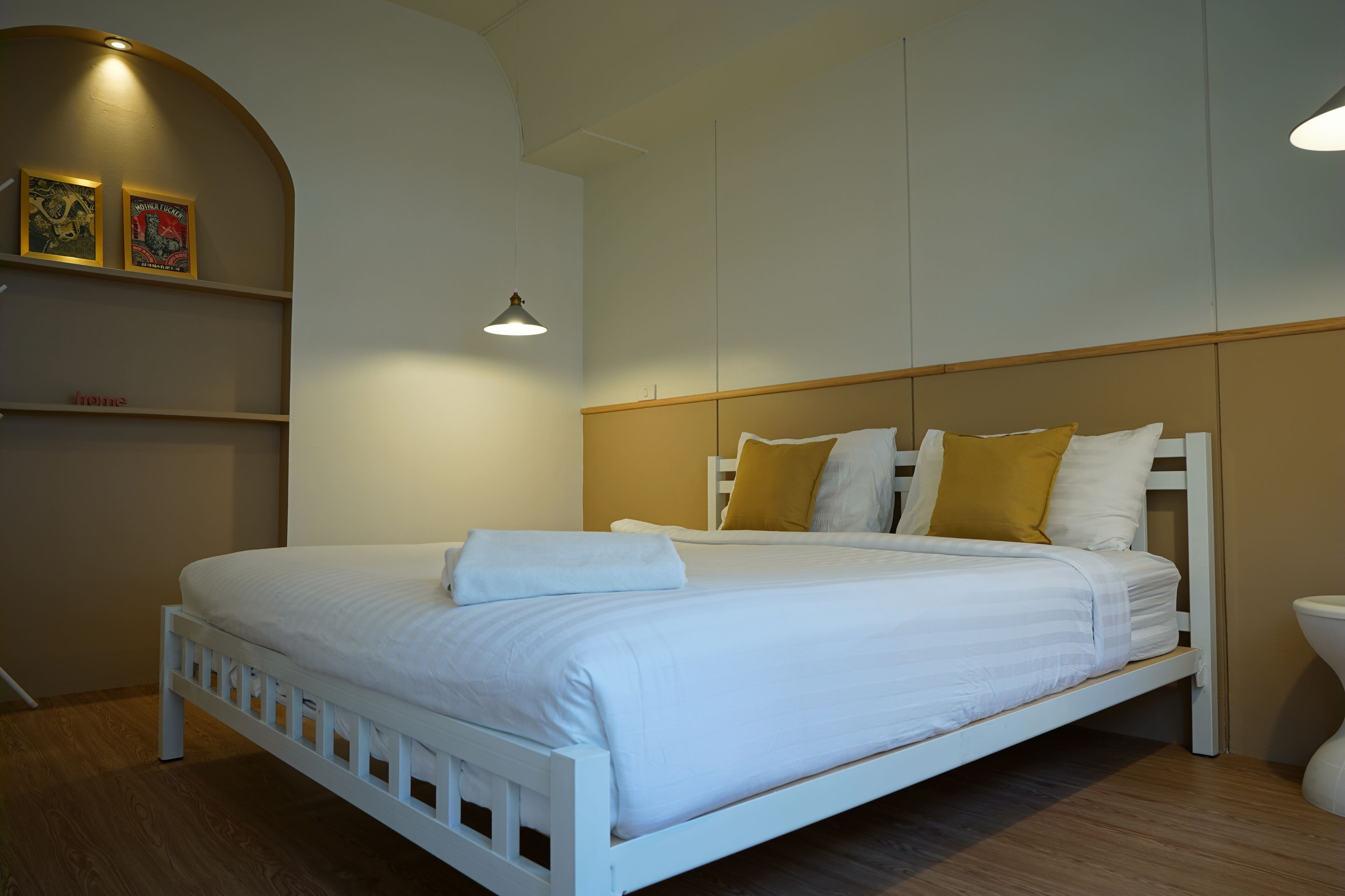 A bed with white bedding, a wooden headboard, and two bedside lamps.