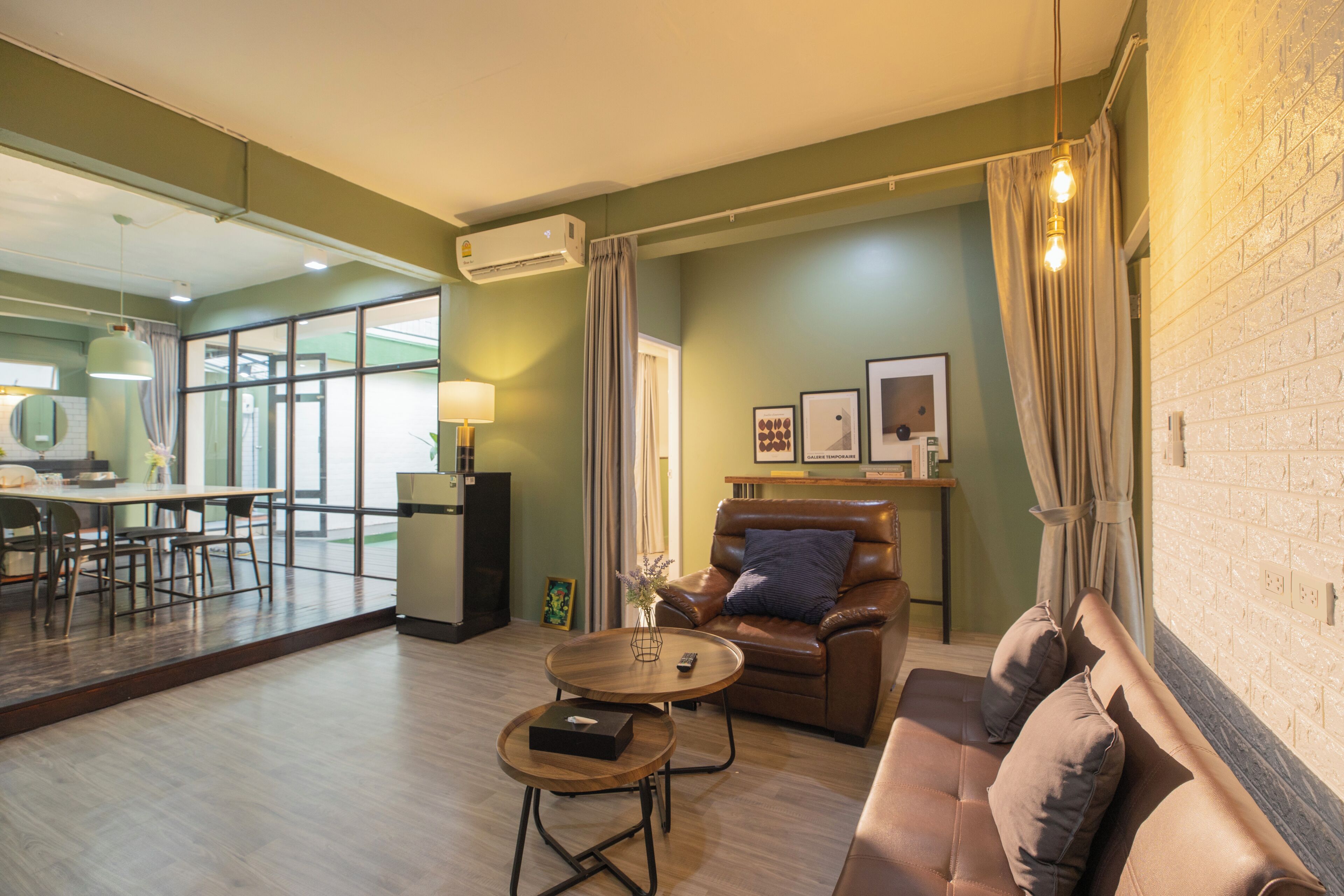 A modern living room with a sofa, a coffee table, and a dining area with a table and chairs.