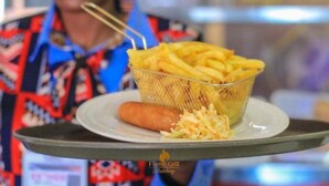 Una bandeja con papas fritas, una salchicha y ensalada de col.