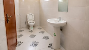 Un baño con inodoro, lavamanos y baldosas de suelo con diseño.