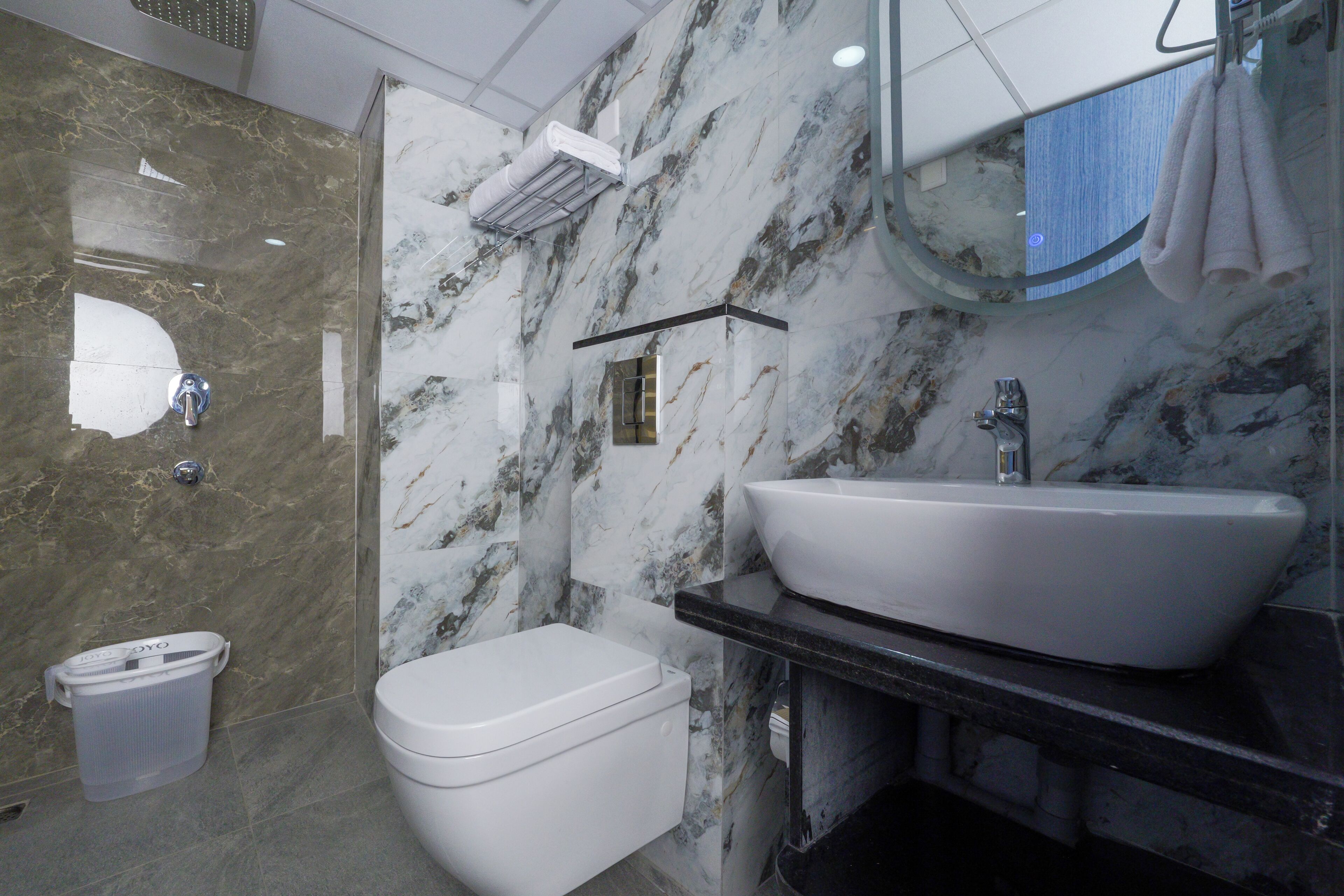 Un baño con un inodoro blanco, un lavabo blanco y un espejo sobre el lavabo.