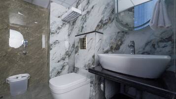 Un baño con un inodoro blanco, un lavabo blanco y un espejo sobre el lavabo.