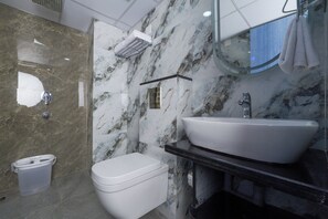 A bathroom with a white toilet, a white sink, and a mirror above the sink.