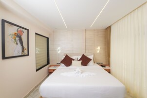 Habitación de hotel con una cama grande, un cuadro en la pared y una mesita de noche con un teléfono.