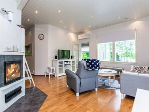 Una sala de estar con chimenea, televisor y sofá.