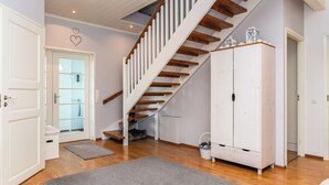 A staircase with wooden steps and white railings, leading to an upper floor.