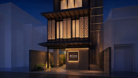 A modern building with a prominent entrance, a sign reading 'Minn your second home,' and a well-lit facade.