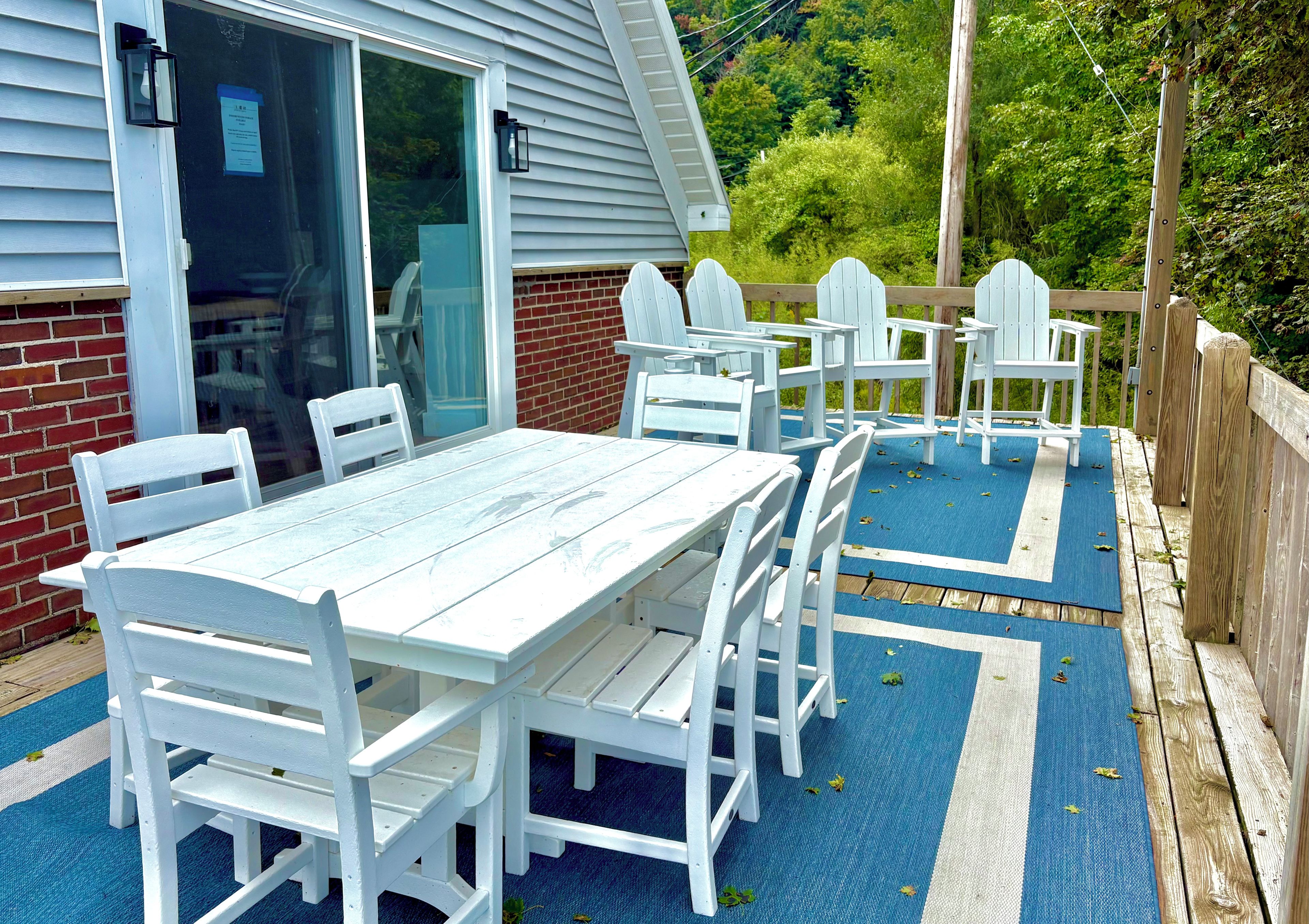 Eine Terrasse mit Tisch und Stühlen, eine Ziegelmauer und ein Holzdeck.