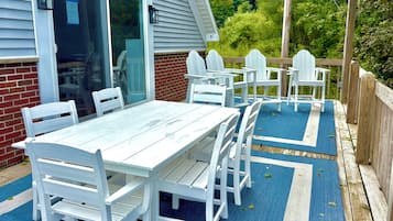 Eine Terrasse mit Tisch und Stühlen, eine Ziegelmauer und ein Holzdeck.