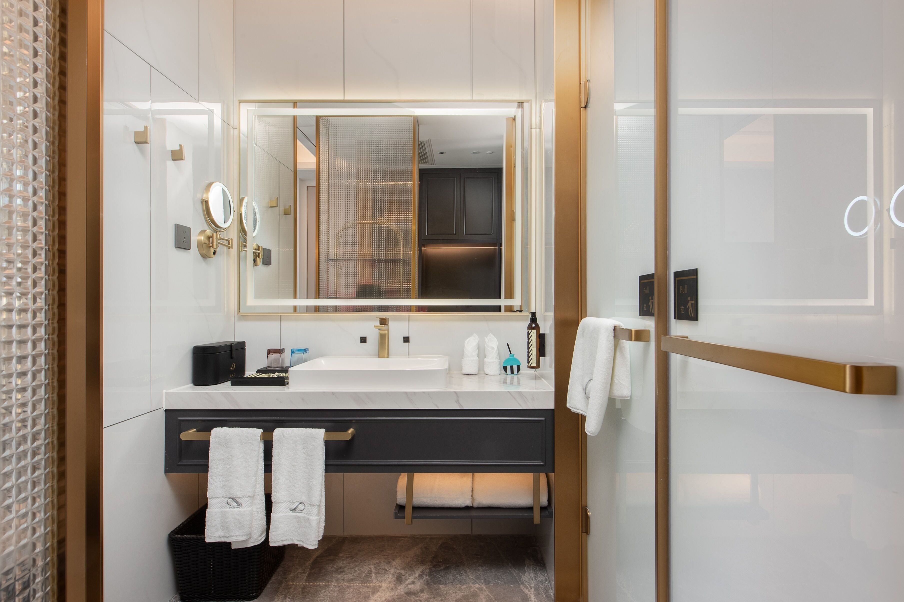 Un baño moderno con un espejo grande, un lavabo y un perchero para toallas.